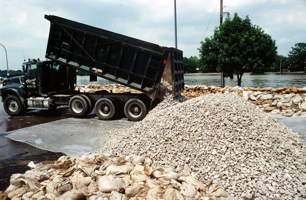 Dump truck unloading crushed stone at a job site